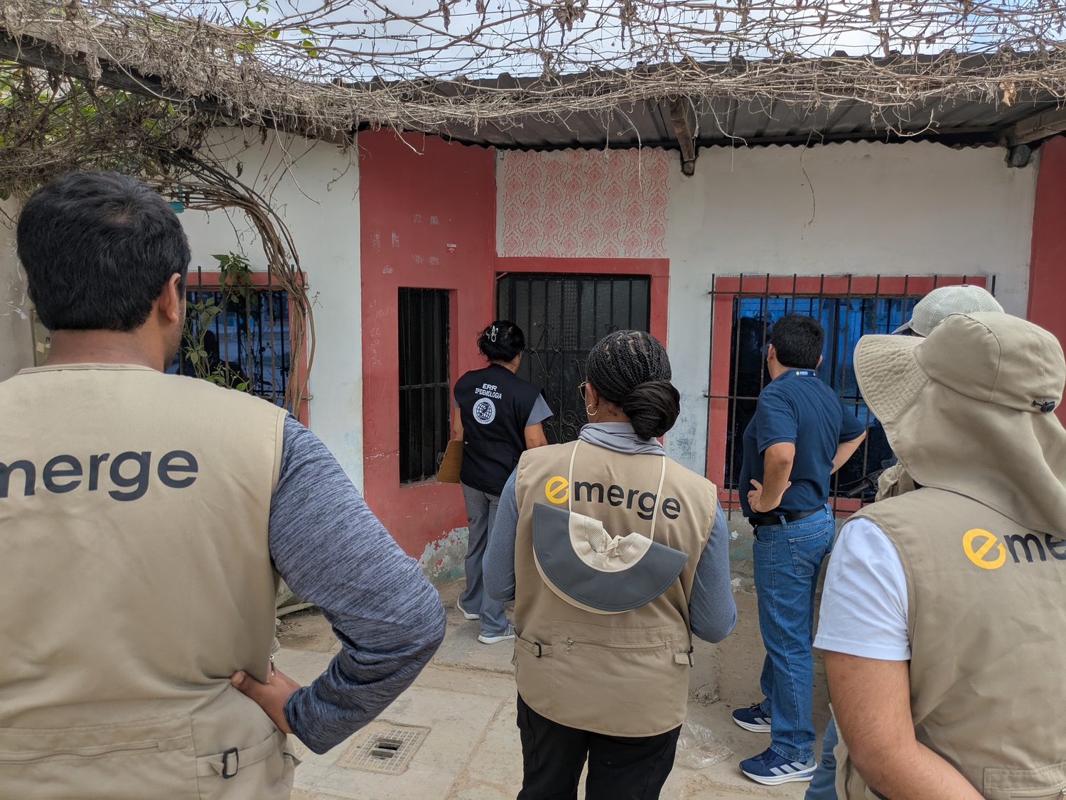 A field team in EMERGE vests conducts house-to-house disease surveillance in a Peruvian neighborhood.