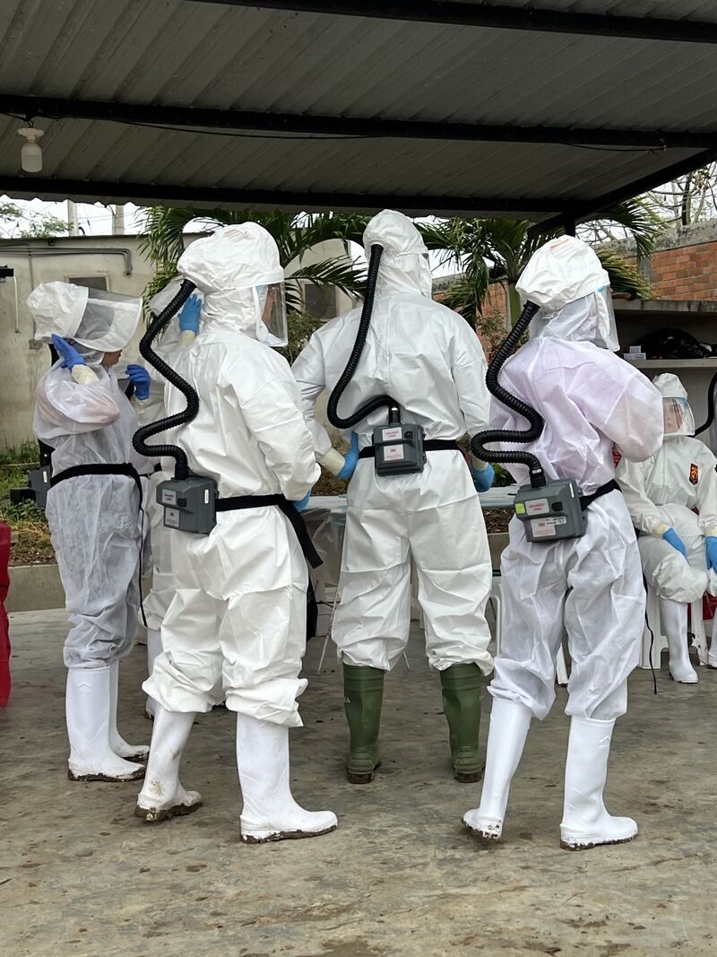 Students in protective suits and respirators during field outbreak-response training in Peru.